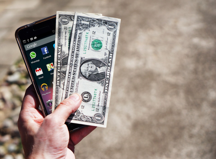 Person showing his phone and money